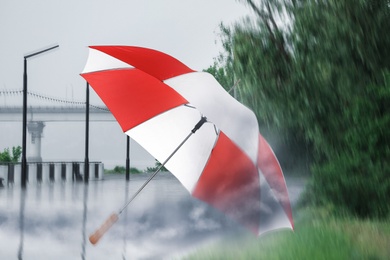 Open umbrella blown by wind gust outdoors