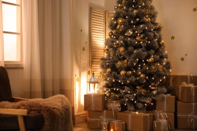 Stylish room interior with beautiful Christmas tree and gift boxes