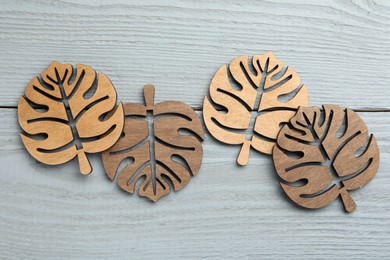 Leaf shaped wooden cup coasters on light grey table, flat lay