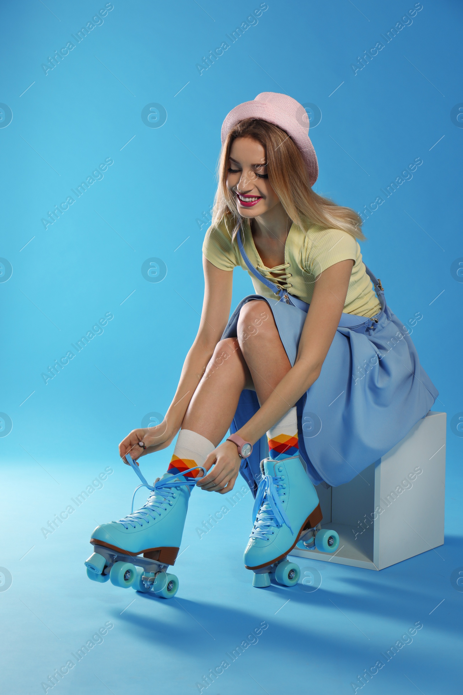 Photo of Young woman with retro roller skates on color background