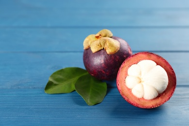 Delicious tropical mangosteens on blue wooden table