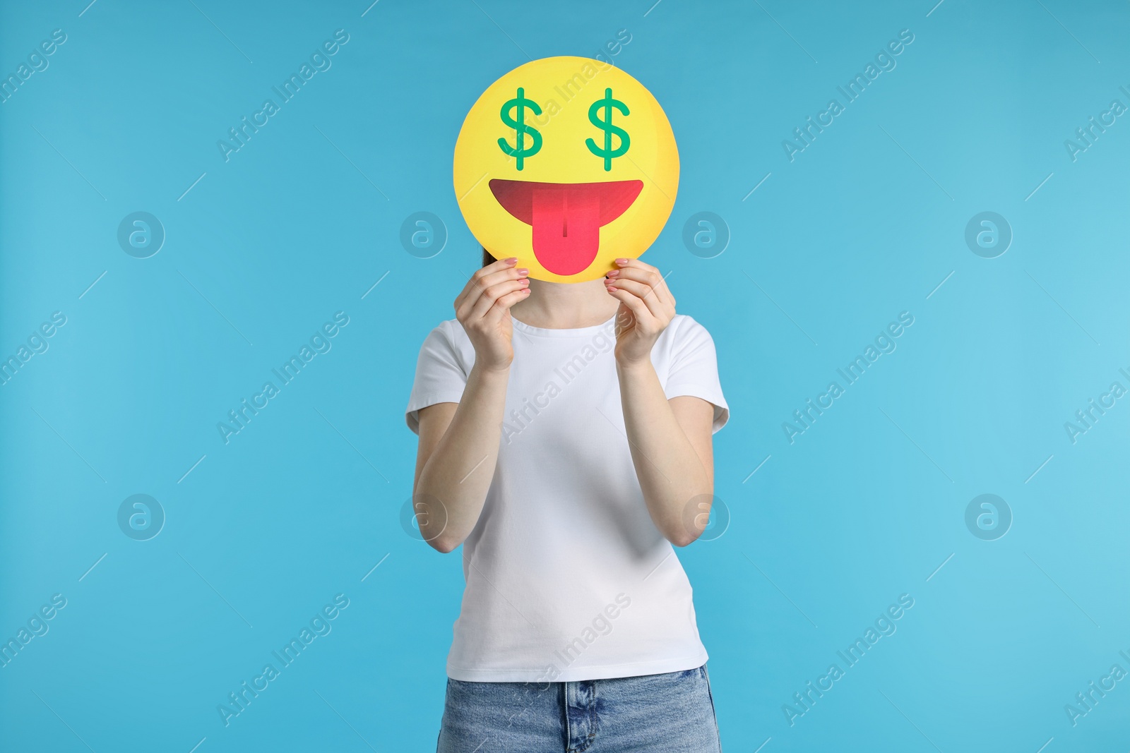 Photo of Woman covering face with dollar signs instead of eyes on light blue background