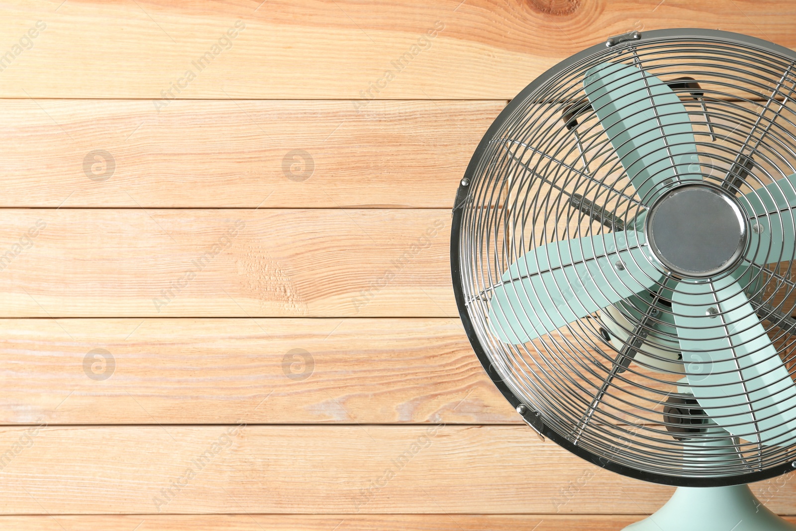 Photo of Electric fan near wooden wall, space copy text. Summer heat