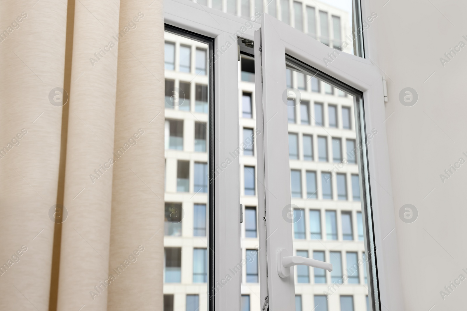 Photo of Open window with white plastic frame indoors