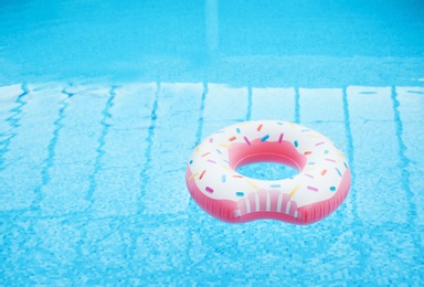 Inflatable ring floating on water in swimming pool