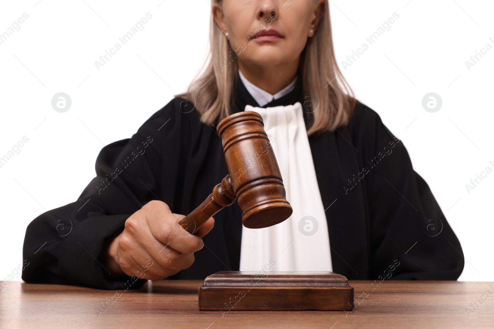 Photo of Judge with gavel at wooden table on white background, closeup