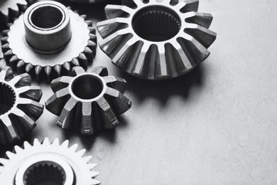 Different stainless steel gears on light grey background, closeup