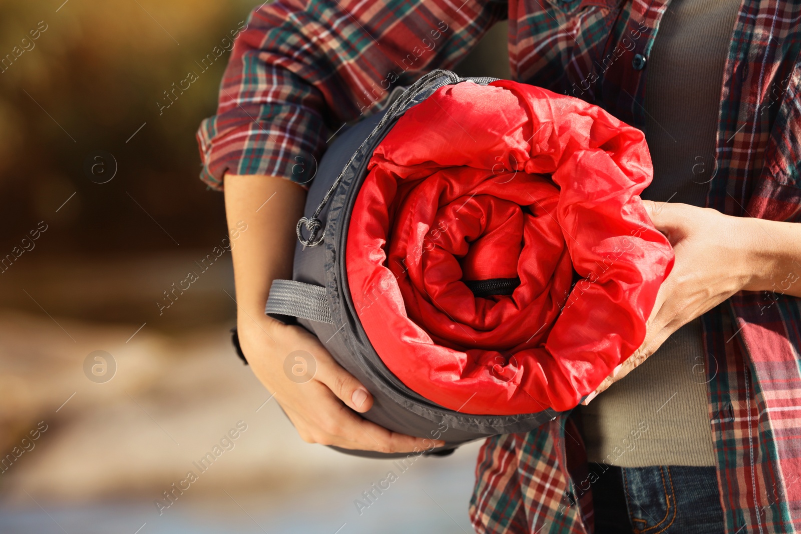 Photo of Female camper with sleeping bag outdoors, closeup