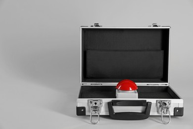 Photo of Red button of nuclear weapon in suitcase on light gray background, space for text. War concept