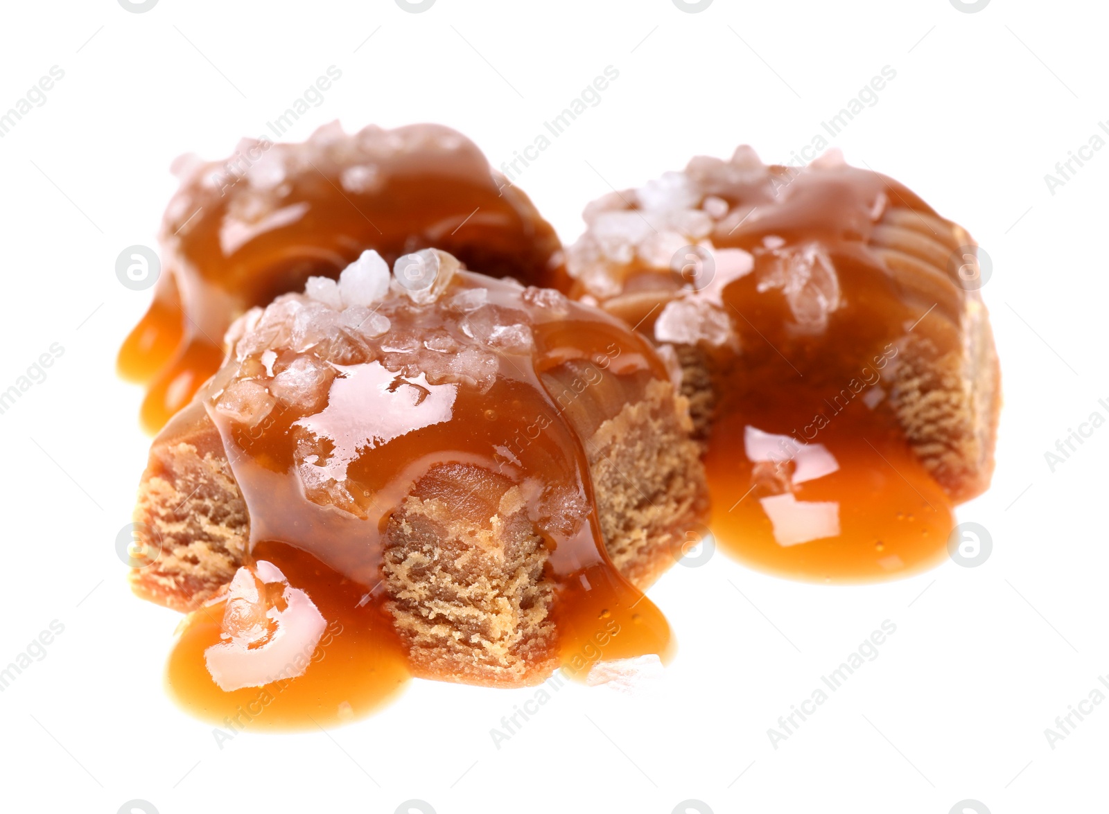 Photo of Delicious salted caramel with sauce on white background