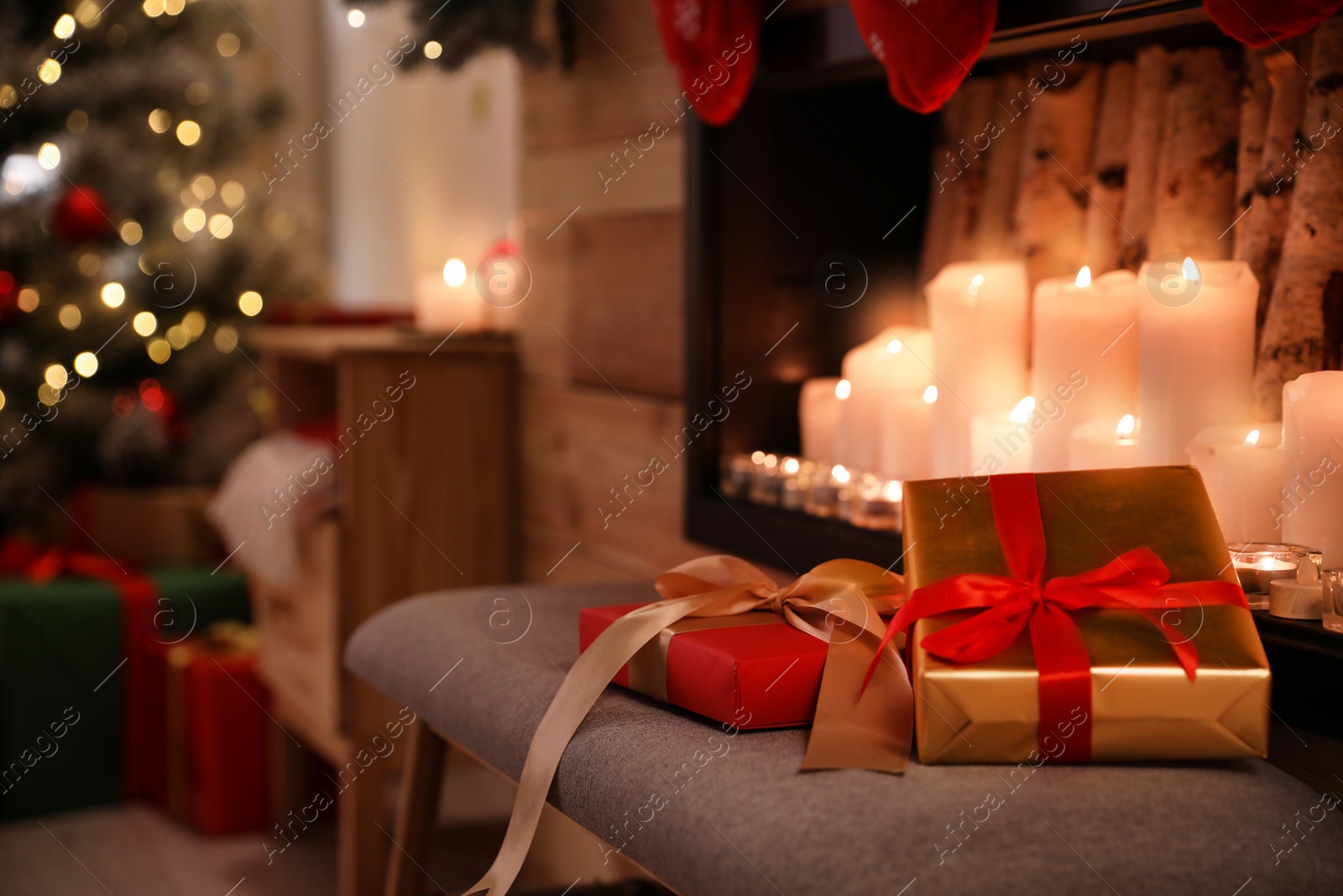 Photo of Christmas gifts on chair in stylish room interior