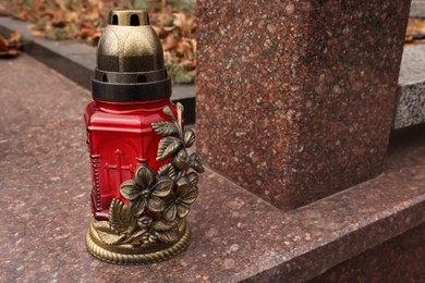 Photo of Grave lantern on granite surface at cemetery, space for text