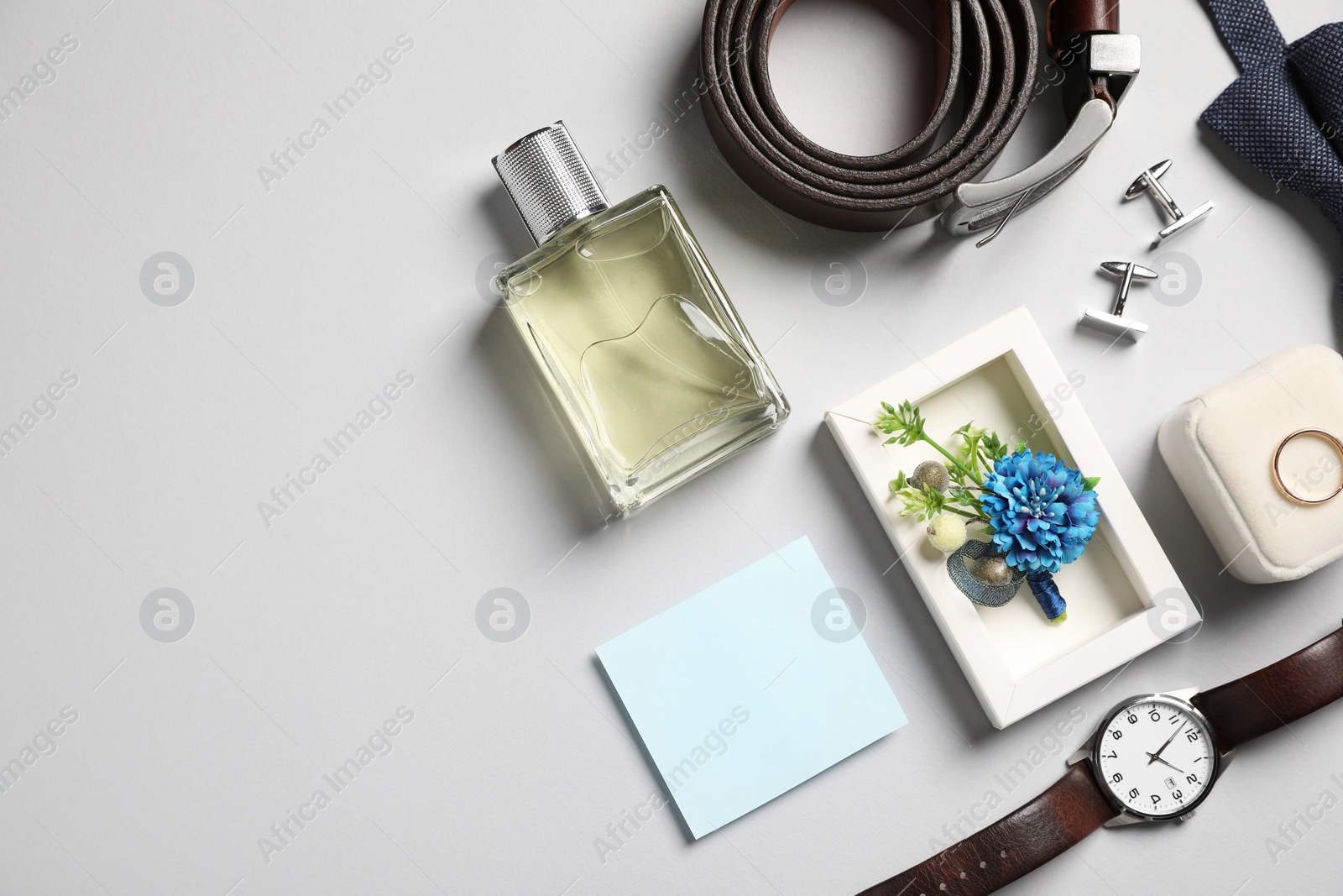 Photo of Wedding stuff. Flat lay composition with stylish boutonniere on light gray background, space for text