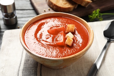 Photo of Bowl with delicious fresh homemade tomato soup on table