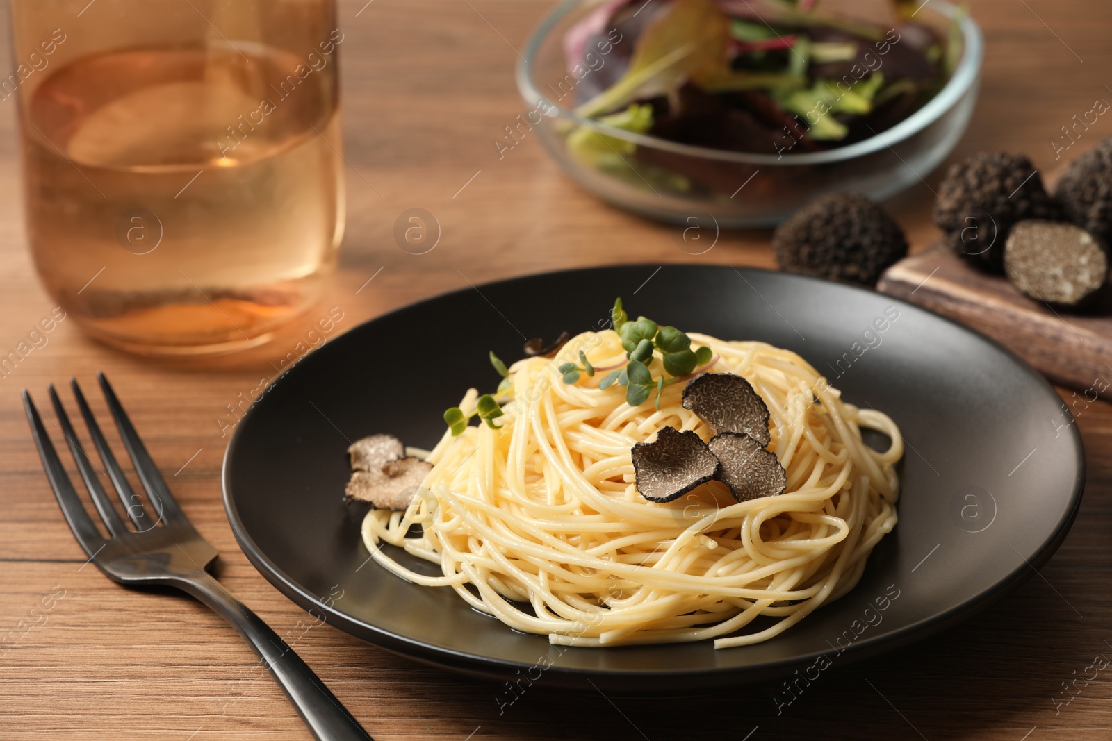 Photo of Tasty spaghetti with truffle on wooden table