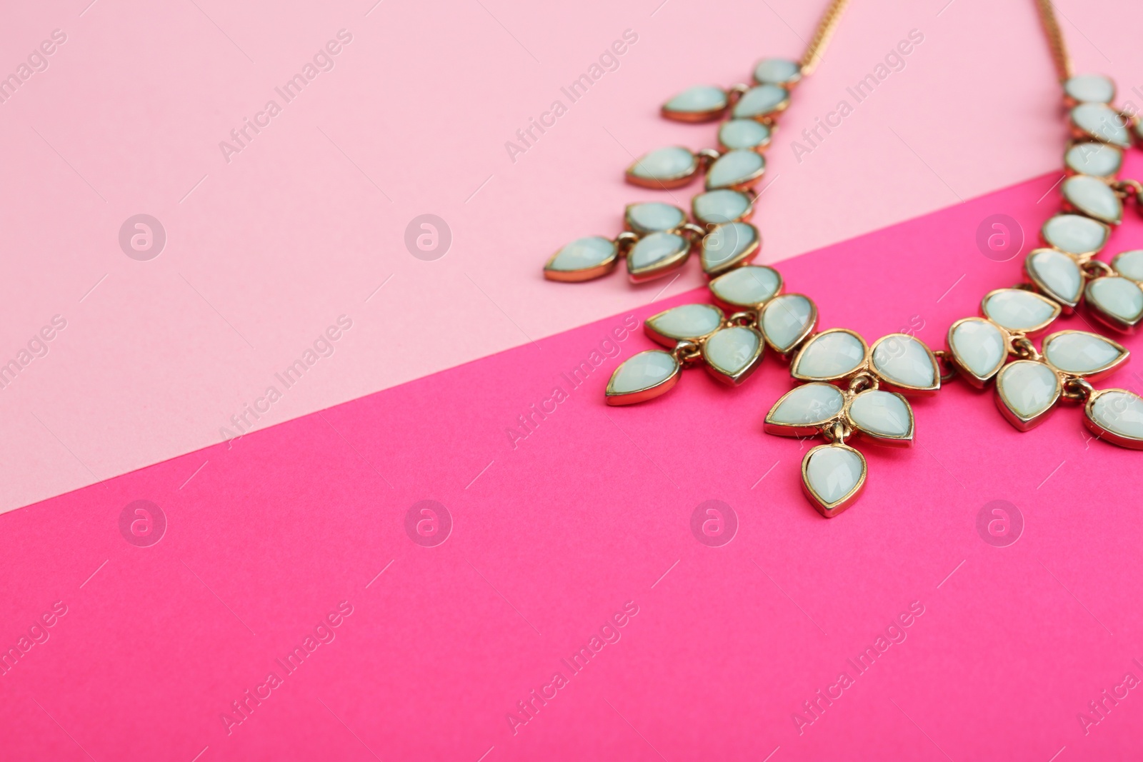 Photo of Beautiful necklace on color background, closeup. Space for text