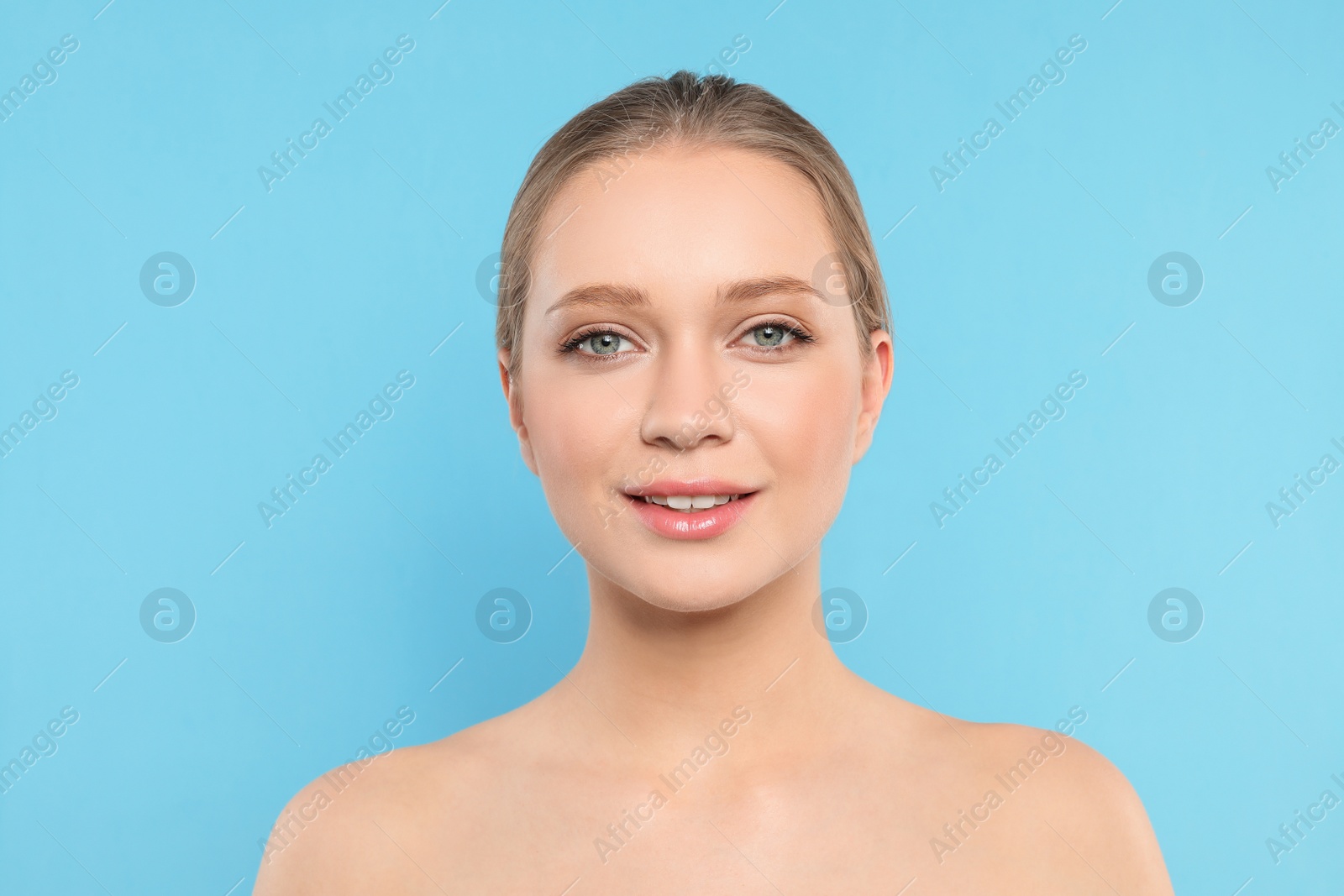 Photo of Portrait of young woman with beautiful face on blue background