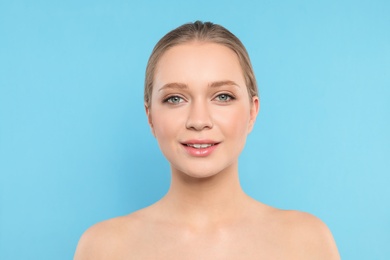 Portrait of young woman with beautiful face on blue background