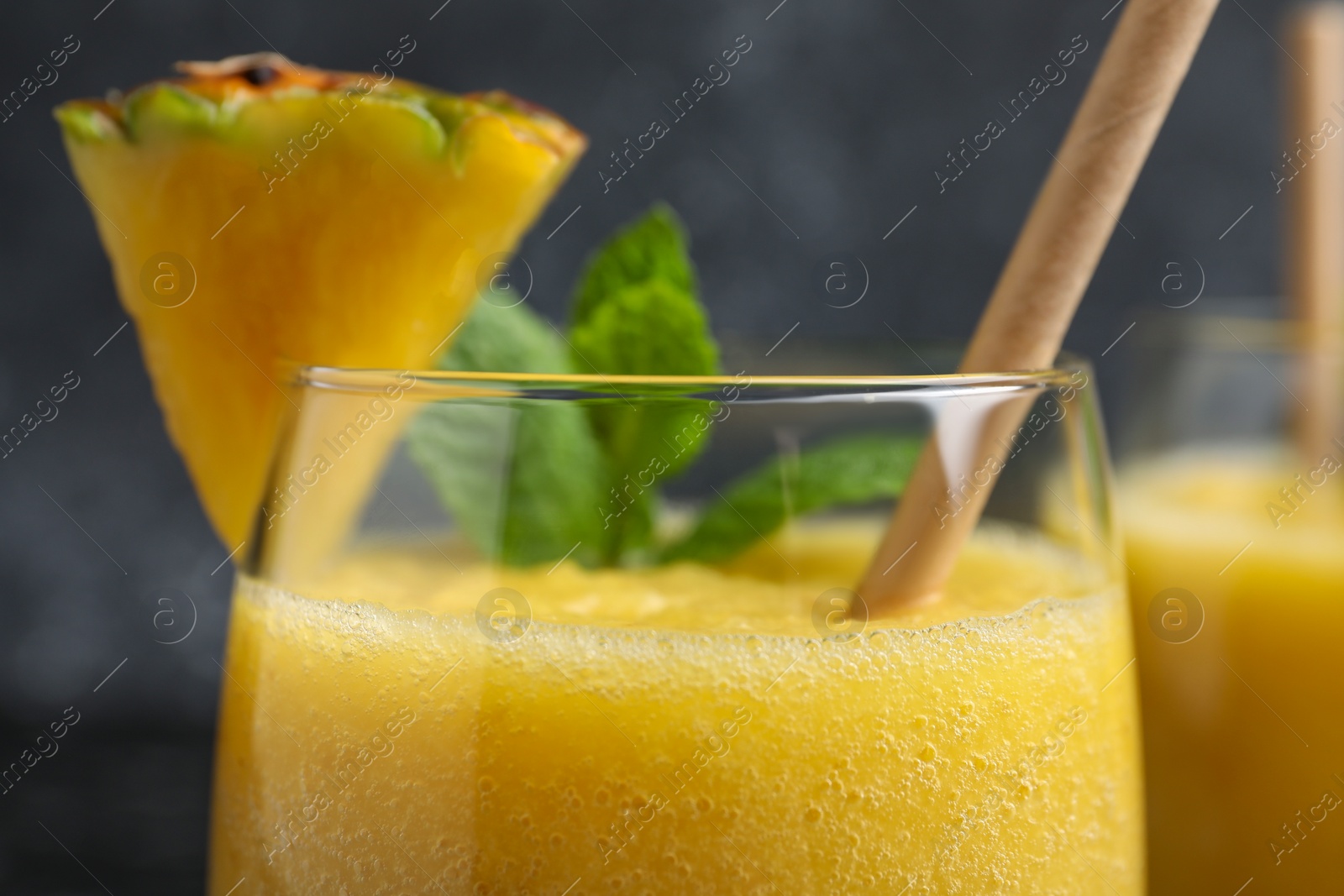 Photo of Tasty pineapple smoothie in glass, closeup view