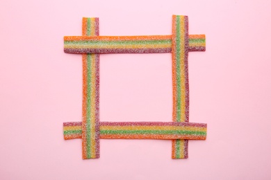 Photo of Frame made with tasty jelly candies on color background, top view. Space for text