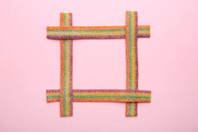 Frame made with tasty jelly candies on color background, top view. Space for text