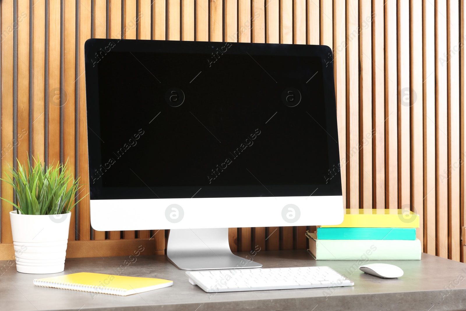 Photo of Computer with blank monitor at table indoors. Mock up for design