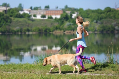 Young woman and her dog spending time together outdoors. Pet care