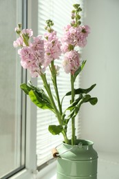 Photo of Beautiful pink flowers in vase on windowsill