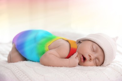 Image of National rainbow baby day. Cute child in colorful onesie sleeping on blanket