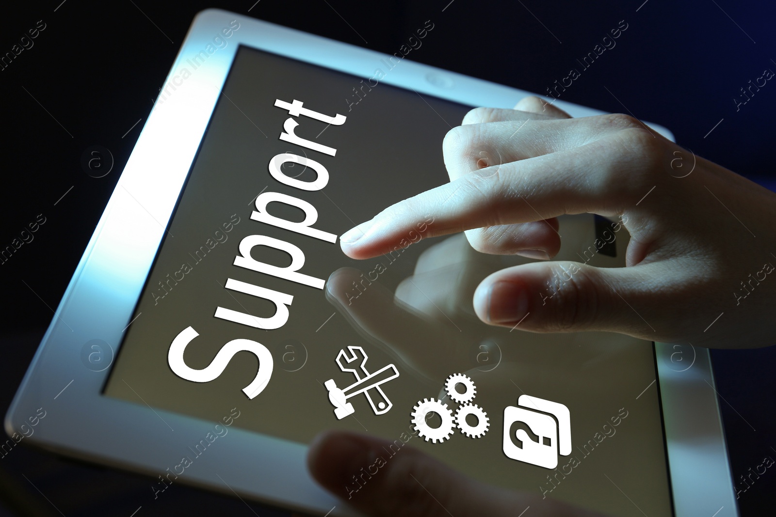 Image of Woman using tablet on dark background, closeup. Technical support service
