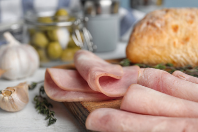 Photo of Tasty ham on white wooden table, closeup