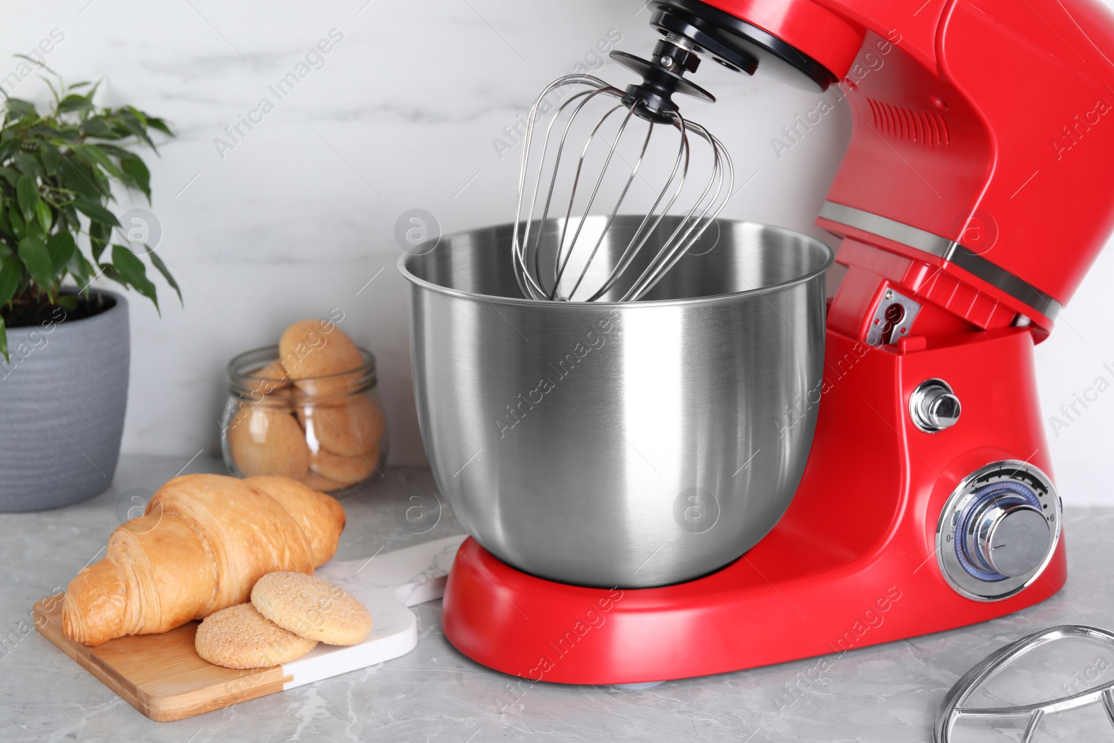 Photo of Modern red stand mixer, croissant and cookies on light gray marble table