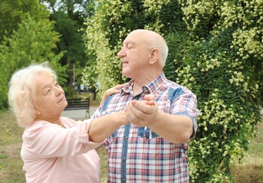 Cute elderly couple in love dancing outdoors