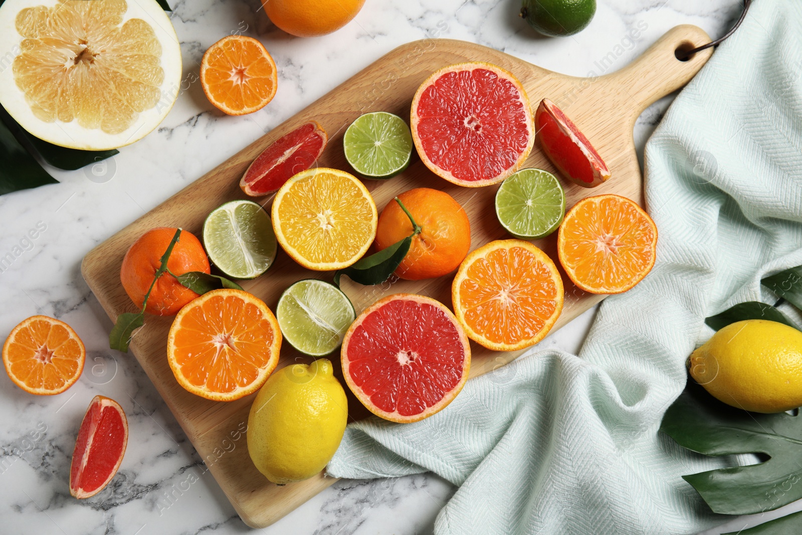 Photo of Different citrus fruits on marble background, top view