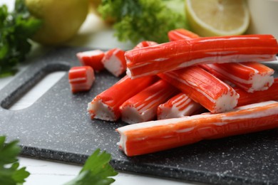 Delicious crab sticks on black board, closeup