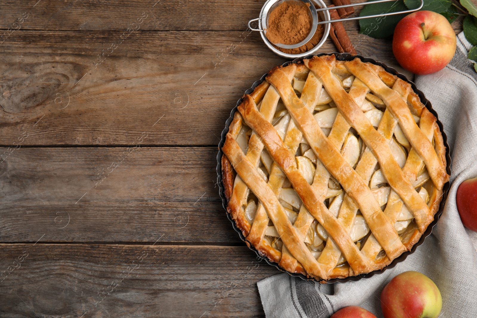 Photo of Delicious traditional apple pie on wooden table, flat lay. Space for text