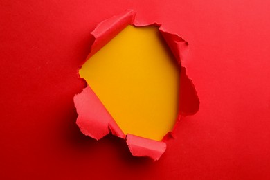 Photo of Hole in red paper on yellow background