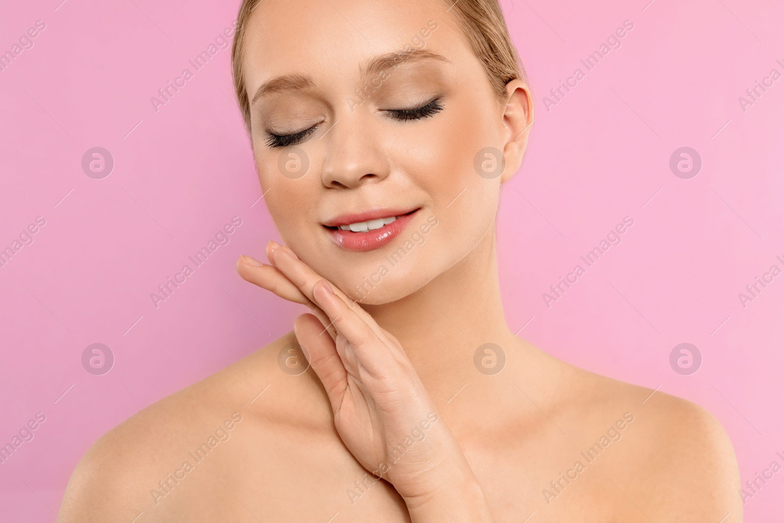 Photo of Portrait of young woman with beautiful face on pink background, closeup