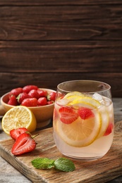 Photo of Natural lemonade with strawberries in glass on table