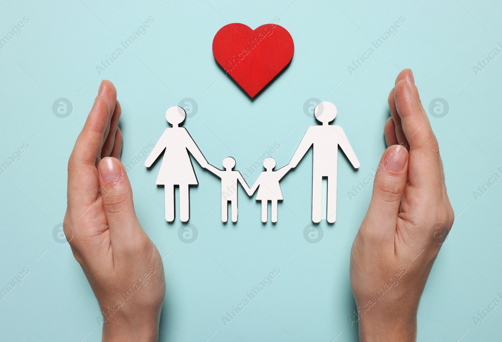 Photo of Woman protecting figures of family and heart on light blue background, top view. Insurance concept