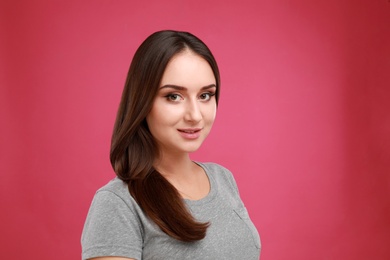Photo of Beautiful young woman in casual outfit on crimson background