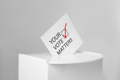 Image of Paper with text Your Vote Matters and tick sticking out of ballot box on light grey background