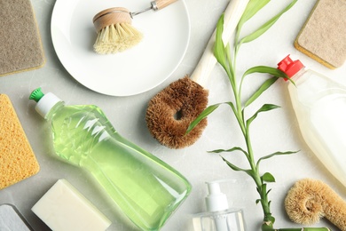 Flat lay composition with cleaning supplies for dish washing on grey table