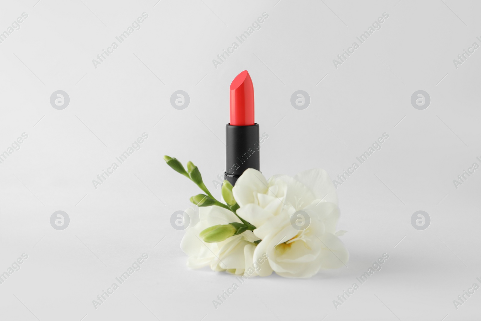 Photo of Beautiful lipstick and flowers on white background