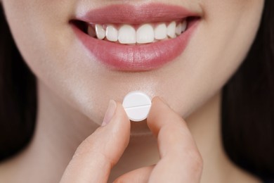 Photo of Closeup view of woman taking one pill