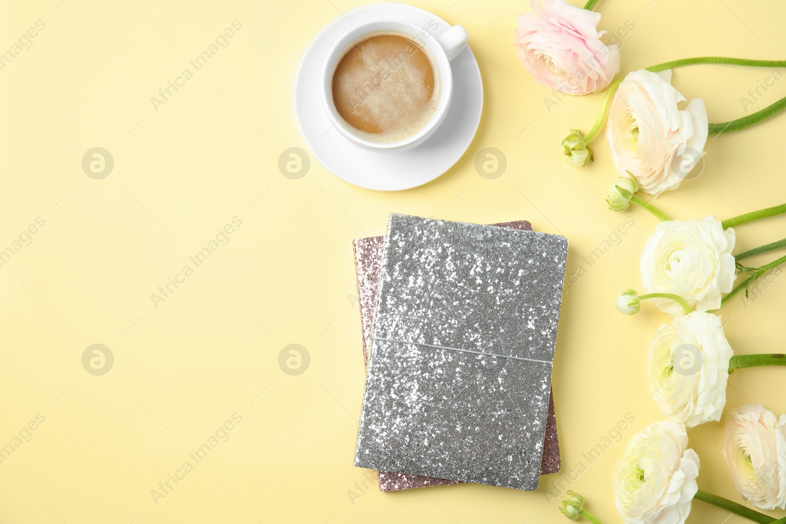 Photo of Flat lay composition with notebooks, coffee and flowers on color background. Space for text