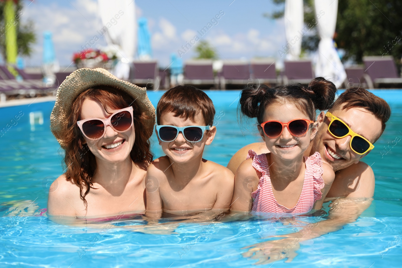 Photo of Happy family in swimming pool at resort