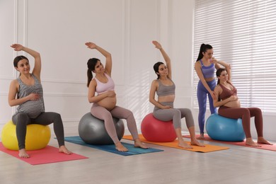 Trainer working with group of pregnant women in gym. Preparation for child birth