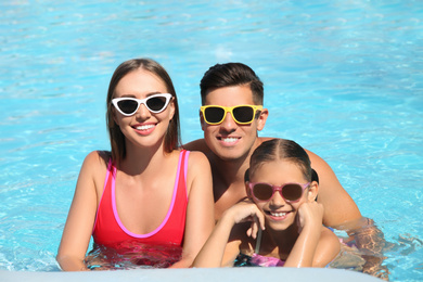 Happy family in swimming pool on sunny day