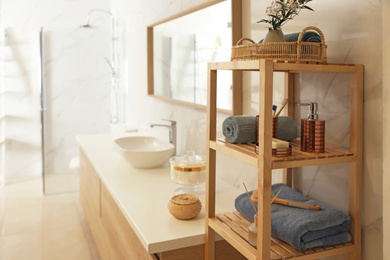 Photo of Shelving unit with toiletries in stylish bathroom interior 